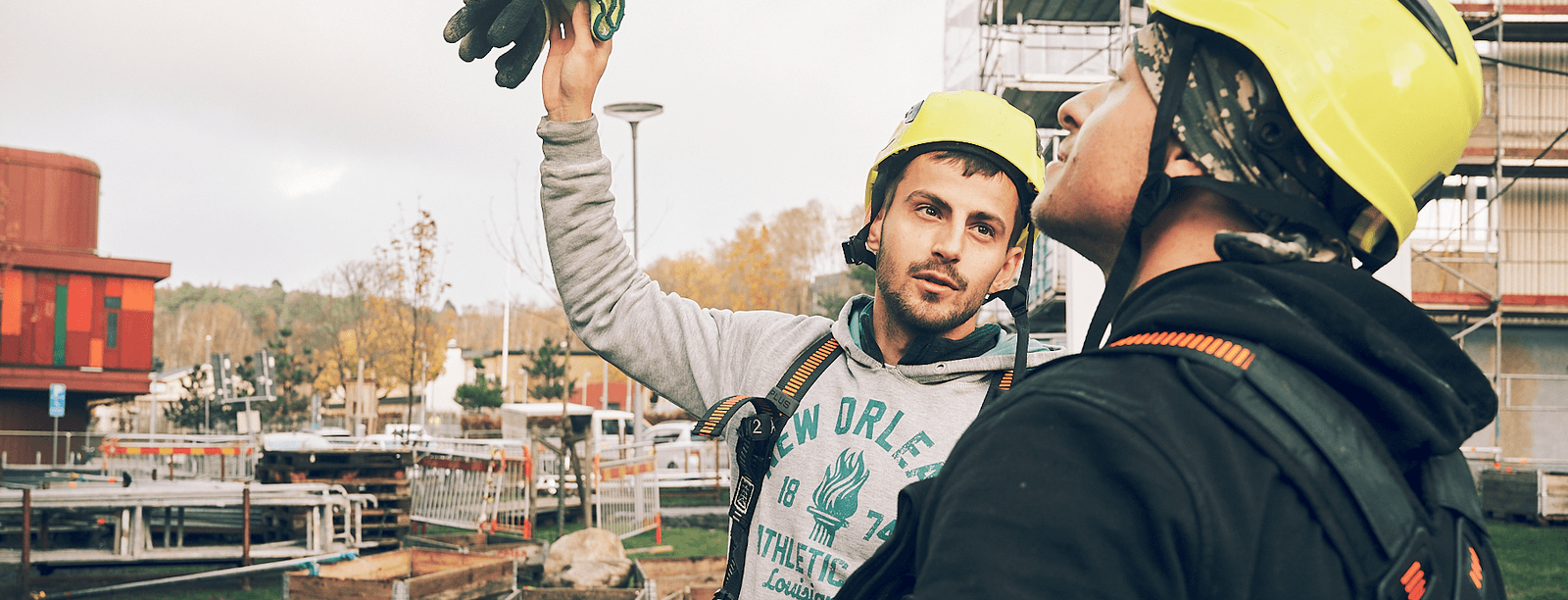 Bild på två byggarbetare, håller upp handske - säkerhet